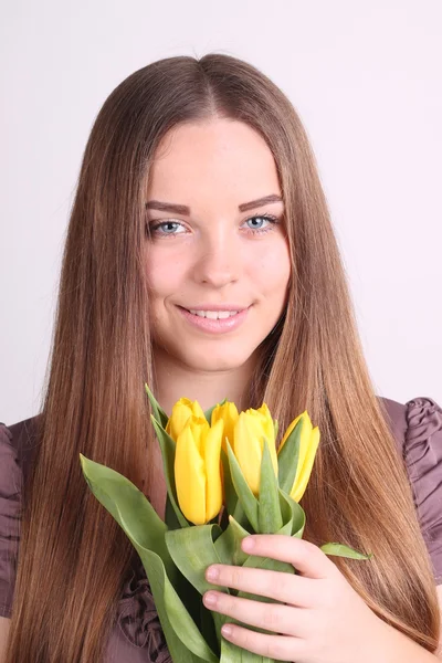 Schöne Frau mit gelben Tulpen — Stockfoto