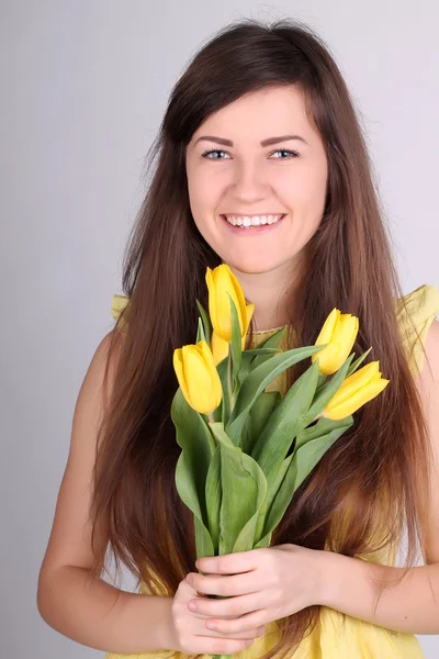 Flicka med gula tulpaner — Stockfoto