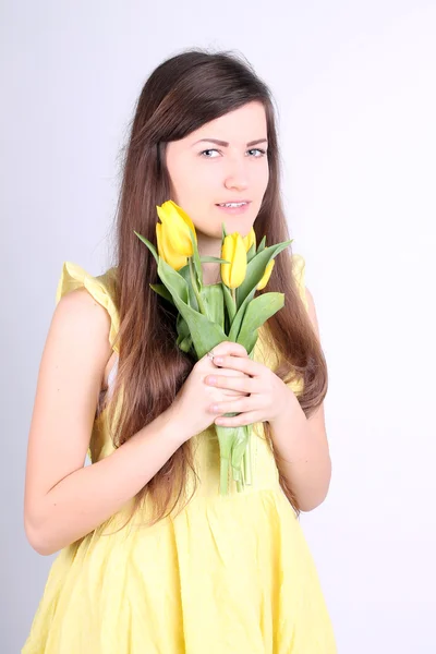 Girl with yellow tulips — Stock Photo, Image