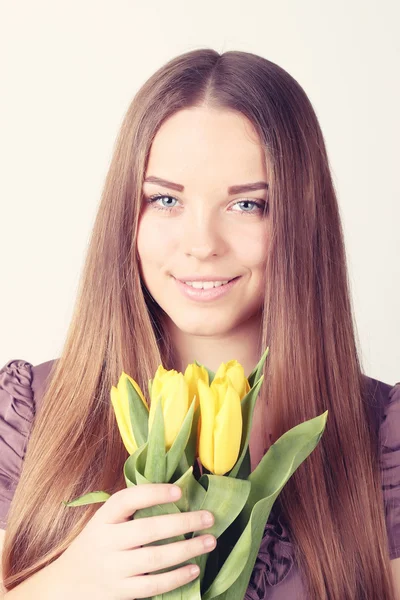 Женщина с длинными волосами с желтыми тюльпанами — стоковое фото