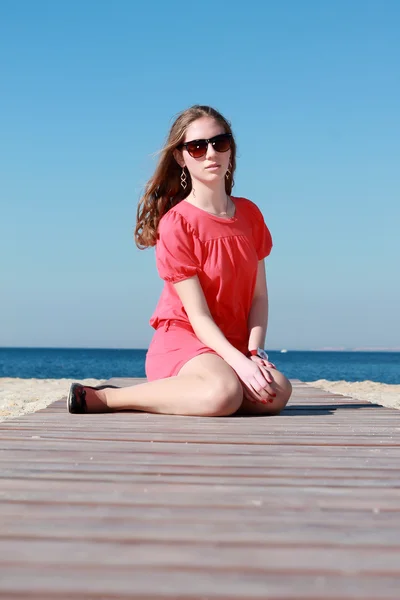Plajda denize yakın oturan genç kız — Stok fotoğraf