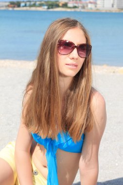 plajda denize yakın oturan genç kız