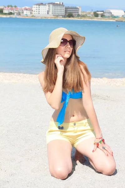 Niña descansando en la playa cerca del mar — Foto de Stock