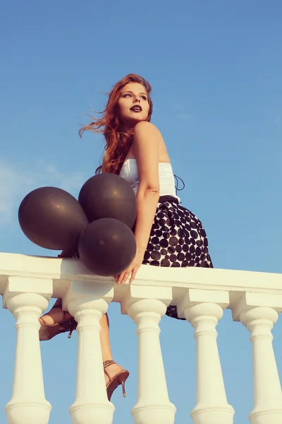 Ein Mädchen mit schwarzen Luftballons. Glam stilvolles modisches Retro-Foto — Stockfoto
