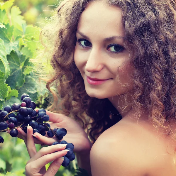 Jeune femme cueillette de raisins — Photo