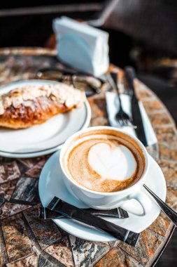 Bir fincan sıcak içecekle birlikte kapuçino kahvesi.