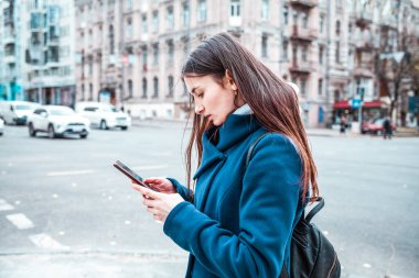 Cep telefonu ve akıllı telefonu olan genç bir kadın.