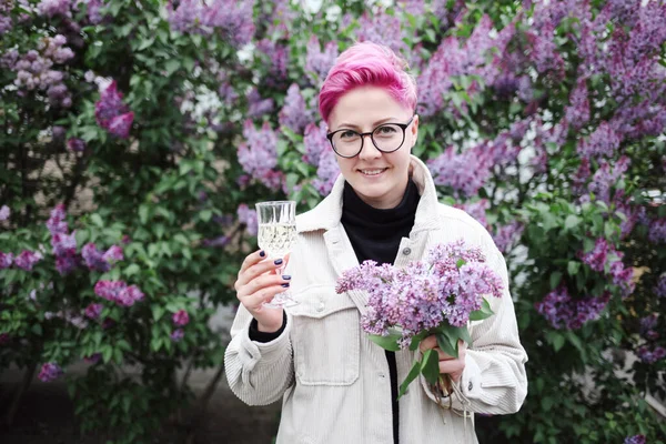開花の庭にピンクの春の花のガラスを持っている女性 — ストック写真