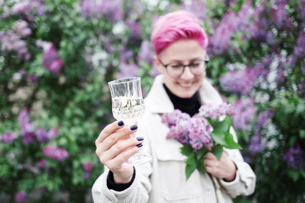 開花の庭にピンクの春の花のガラスを持っている女性 — ストック写真