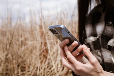 Parkta cep telefonu kullanan bir kadın.