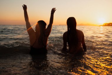 Gün batımında sahilde mutlu genç Çift