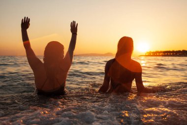 Deniz kıyısındaki genç mutlu çiftin siluetleri.