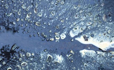 Asfalt yol birikintilerindeki soyut desenler.