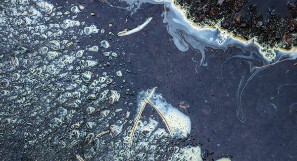 Asfalt yol birikintilerindeki soyut desenler.