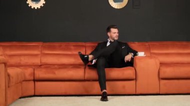 Klasik ceketli adam kanepede.