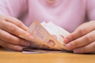 Asyalı kadın para sayma hesap makinesi ile kapatın. Kadın hesaplamak evde harcama.