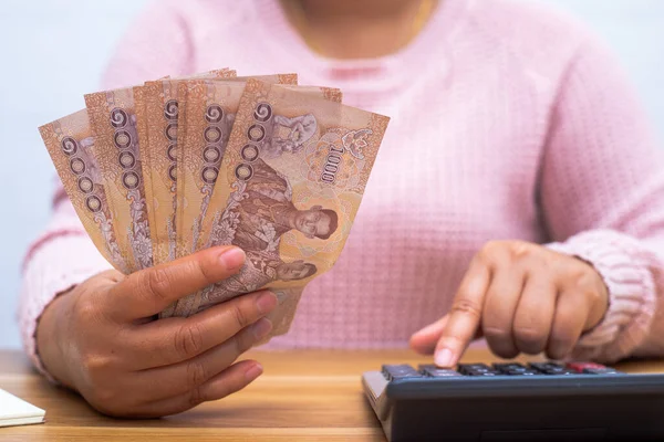 Asyalı kadın para sayma hesap makinesi ile kapatın. Kadın hesaplamak evde harcama.