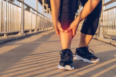 Kadın yaya köprüsünde bacak masajı yapıyor.