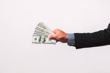 Takım elbiseli bir işadamının elinde birkaç yüz dolarlık banknotlar var. Finans kavramı.