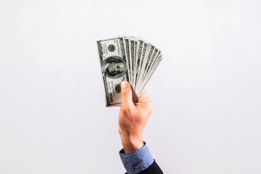Takım elbiseli bir işadamının elinde birkaç yüz dolarlık banknotlar var. Finans kavramı.