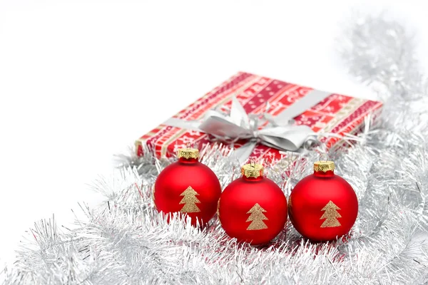 Three red christmas ball and present on white background — Stock Photo, Image