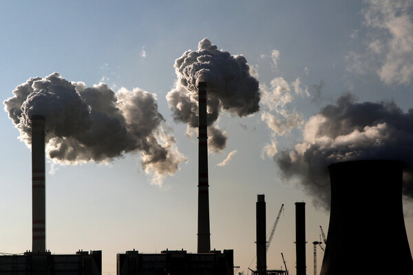 Coal smoking power plant against the sun