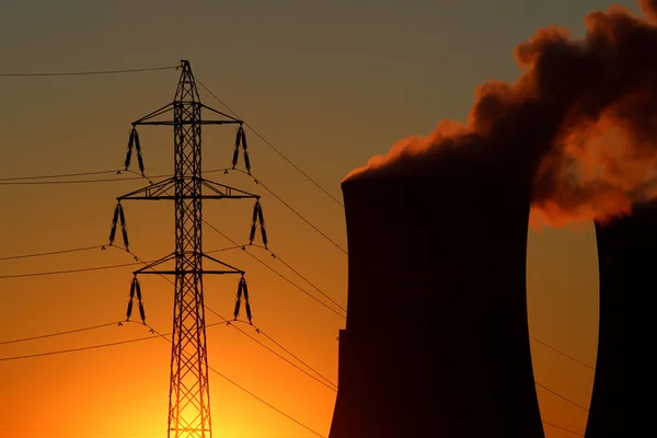 Torre de alto voltaje y central eléctrica durante la puesta del sol —  Fotos de Stock