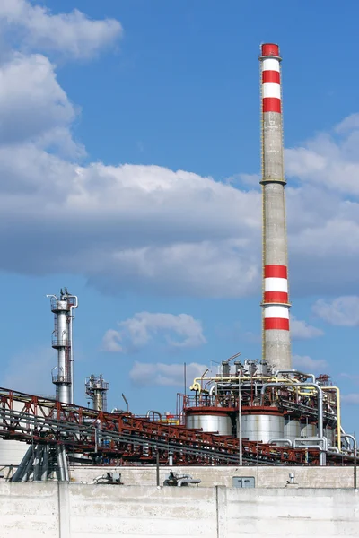 Alta chimenea de la refinería de petróleo bajo el cielo —  Fotos de Stock