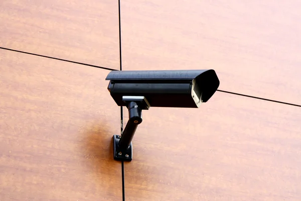 Black CCTV security camera on brown bacground