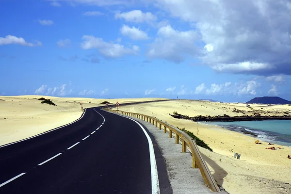Strada nera attraverso dune sabbiose — Foto Stock