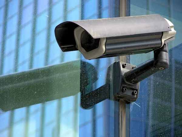 Камера видеонаблюдения на стеклянном фасаде — стоковое фото