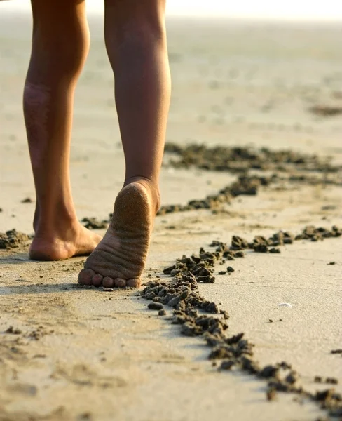 Niña y sus piernas en la playa — Foto de Stock