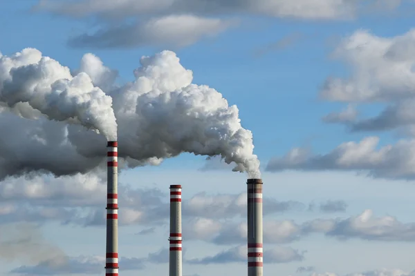 Tres chimeneas y humo blanco contaminado cielo — Foto de Stock