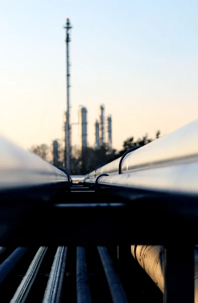 Long pipe and silhouette of oil refinery — Stock Photo, Image