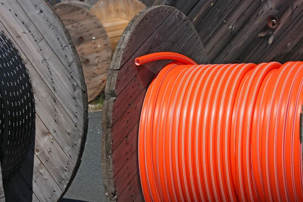 Bobines en bois avec câbles noirs et orange — Photo