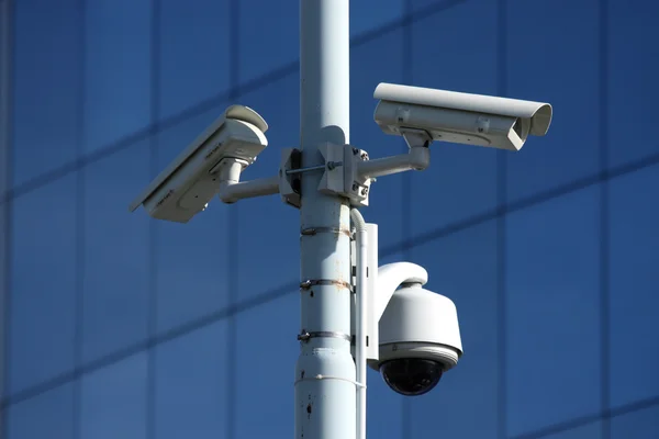 Três câmeras de segurança na frente do edifício de vidro — Fotografia de Stock