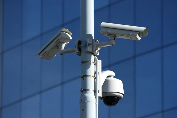 Trois caméras de sécurité sur l'avant du bâtiment en verre — Photo