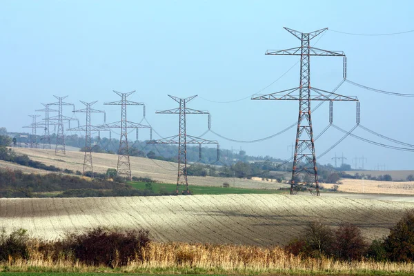 Hoogspanning transmissie torens in lijn — Stockfoto