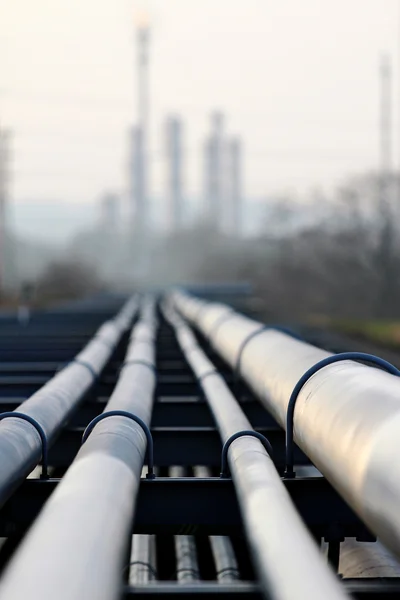 Crude oil pipeline and oil  refinery against light — Stock Photo, Image