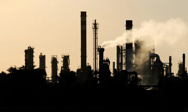 Silueta de la estación de refinería de petróleo crudo durante el atardecer — Foto de Stock