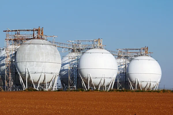 Campo de tanques de petróleo bruto no campo da agricultura — Fotografia de Stock