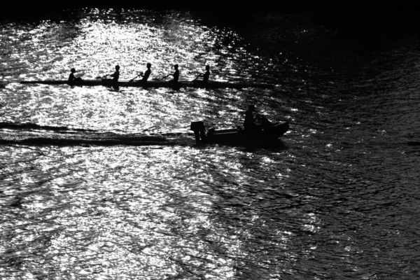 Boat with four rowers and helmsman on river water Royalty Free Stock Images