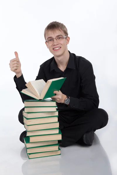Estudiante con una pila de libros sobre fondo blanco — Foto de Stock