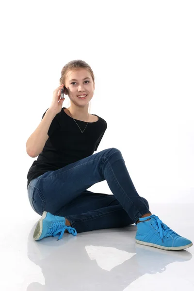 Beautiful girl sitting in the studio talking on the phone — Stock Photo, Image