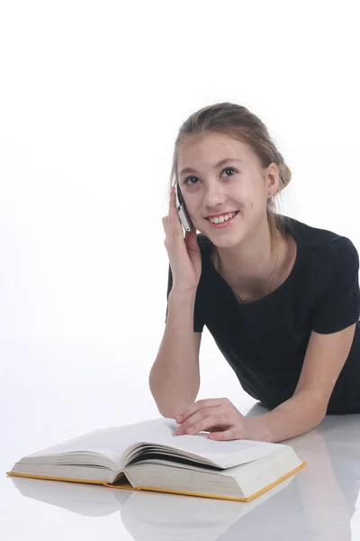 Skolflicka med bok och telefon — Stockfoto