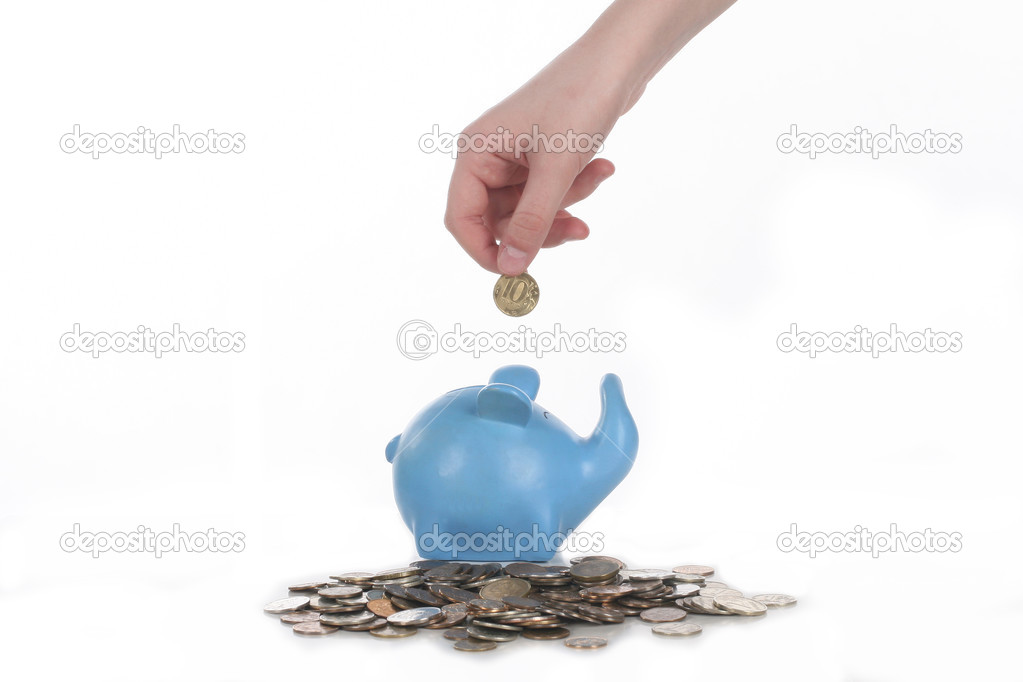 hand puts a coin in a piggy bank