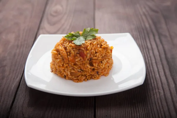 Jollof Arroz Cocido Plato Blanco Sobre Fondo Marrón Madera — Foto de Stock