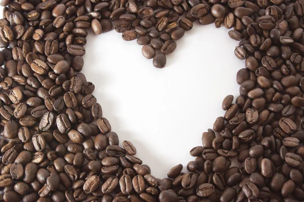 Vitt hjärta i ramen av kaffebönor — Stockfoto