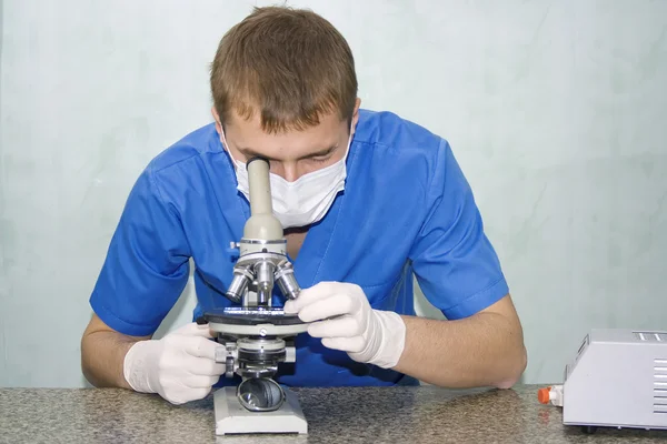 Médecin regardant dans un microscope — Photo