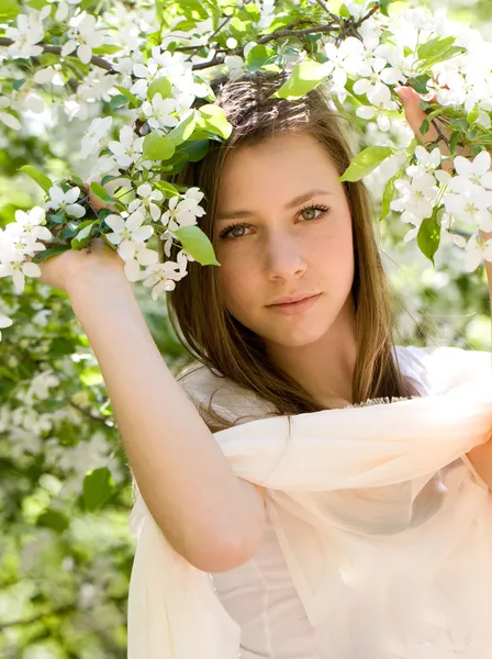 Chica joven en blanco en el jardín floreciente de primavera — Foto de Stock